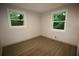 Cozy bedroom showcasing two windows providing natural light, paired with modern hardwood flooring at 2926 Monterey Dr, Decatur, GA 30032