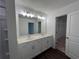 Modern bathroom featuring double vanity sinks, stylish light fixtures, and a walk-in closet at 1115 Lockhart Way, Douglasville, GA 30135