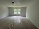 Large bedroom with plastic sheeted flooring and lots of natural light from two windows at 1115 Lockhart Way, Douglasville, GA 30135