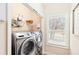 Functional laundry room equipped with a modern washer and dryer set, storage shelving at 275 Cedars, Villa Rica, GA 30180