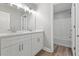 Bathroom with double vanity, white cabinets, and a tub with shower at 5341 Stewart Mill Rd, Douglasville, GA 30135