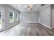 A large, bright living room featuring three large windows, a back door, and modern gray walls at 5341 Stewart Mill Rd, Douglasville, GA 30135