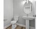 Compact half bath with a pedestal sink, modern toilet, and neutral wall color at 5341 Stewart Mill Rd, Douglasville, GA 30135