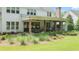 Rear covered porch with an outdoor fireplace, dining area, and beautiful landscaping at 104 Trinity Hollow Dr, Canton, GA 30115