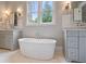 Elegant bathroom features a soaking tub beneath a window, complemented by dual vanities and soft, neutral tones at 104 Trinity Hollow Dr, Canton, GA 30115