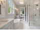 Well-lit bathroom featuring a soaking tub, walk-in shower, dual vanities and doorway to another room at 104 Trinity Hollow Dr, Canton, GA 30115
