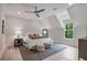 Attic bedroom featuring a cozy bed, modern ceiling fan, and a large window with scenic outdoor views at 104 Trinity Hollow Dr, Canton, GA 30115