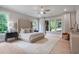 Primary bedroom features hardwood floors, large windows, and ceiling fan at 104 Trinity Hollow Dr, Canton, GA 30115