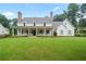 Expansive front yard of charming two-story home with a covered porch and classic rocking chairs at 104 Trinity Hollow Dr, Canton, GA 30115