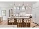 Bright kitchen with an island and bar seating under pendant lights, alongside white cabinets and stainless appliances at 104 Trinity Hollow Dr, Canton, GA 30115