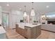 Open-concept kitchen featuring an island with seating, stainless steel appliances, and a view into the living room at 104 Trinity Hollow Dr, Canton, GA 30115