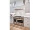 Chef's kitchen with a stainless steel range, pot filler, and custom vent hood at 104 Trinity Hollow Dr, Canton, GA 30115