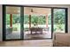 Covered outdoor dining area featuring stone floors, wood columns, ceiling fan, and a view of the spacious backyard at 104 Trinity Hollow Dr, Canton, GA 30115