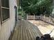 View of the wooden deck with a lawn mower and partial views of backyard foliage at 512 Rockborough Ter, Stone Mountain, GA 30083