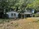 Modest single-story home featuring simple landscaping, a carport and mature trees providing shade at 512 Rockborough Ter, Stone Mountain, GA 30083