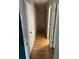 Hallway with laminate wood flooring, white doors, and neutral wall paint at 512 Rockborough Ter, Stone Mountain, GA 30083