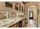 Beautiful bar area with a gorgeous countertop, mirrored backsplash, and display cabinets for glassware and spirits at 829 Big Horn Holw, Suwanee, GA 30024