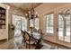 Charming dining area features a rustic chandelier, brick accent wall, and natural light filtering through large windows at 829 Big Horn Holw, Suwanee, GA 30024