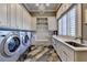 Bright laundry room with three modern appliances, ample counter space, and a stylish patterned floor at 829 Big Horn Holw, Suwanee, GA 30024