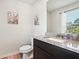 Clean powder room with granite countertop, dark vanity and decorative accents at 1363 Midnight Ride Ct, Hampton, GA 30228
