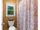 Colorful bathroom with large patterned shower curtain and toilet with decor on top at 3820 Ridge Point Dr, Suwanee, GA 30024