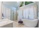 Bright bathroom boasts glass enclosed shower and separate soaking tub with bright lighting at 3820 Ridge Point Dr, Suwanee, GA 30024
