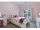 Bright bedroom with neutral carpet, a pink accent wall, and vanity table at 3820 Ridge Point Dr, Suwanee, GA 30024