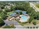 Aerial view showing tennis courts, a swimming pool, ample parking, and a surrounding lush landscape at 3820 Ridge Point Dr, Suwanee, GA 30024