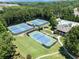 Aerial view of three tennis courts adjacent to the pool and clubhouse amenities at 3820 Ridge Point Dr, Suwanee, GA 30024