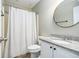 Well-lit bathroom featuring a round decorative mirror, granite countertop vanity, and shower-tub combo at 675 Mayes, Powder Springs, GA 30127