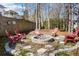 A backyard fire pit area features a stone firepit and several red Adirondack chairs at 949 Tumlin Trce, Lawrenceville, GA 30045