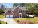 Brick two-story home featuring a two-car garage, landscaped front yard, and inviting entrance at 949 Tumlin Trce, Lawrenceville, GA 30045