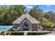 View of the community pool house and playground surrounded by mature trees and lush landscaping at 949 Tumlin Trce, Lawrenceville, GA 30045
