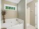 Bathroom features a soaking tub, separate shower, and a bright window providing natural light at 2995 Ivy Mill Dr, Buford, GA 30519