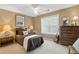 Cozy carpeted bedroom with neutral walls, ceiling fan, and bright window providing natural light at 2995 Ivy Mill Dr, Buford, GA 30519