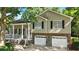 Inviting two-story home with a porch, two-car garage, and well-maintained lawn creates a warm and welcoming curb appeal at 2995 Ivy Mill Dr, Buford, GA 30519