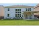 Expansive backyard with a well-maintained lawn, a covered patio area, and a row of flowering bushes along the house at 3222 Long Creek Dr, Buford, GA 30519
