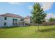 A large backyard with a lush lawn and a wooden fence, alongside a house featuring a covered patio area at 3222 Long Creek Dr, Buford, GA 30519