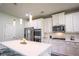 Bright open kitchen with white cabinets, stainless steel appliances, and a center island at 3222 Long Creek Dr, Buford, GA 30519