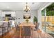 Dining room with modern chandelier, access to patio, and adjacent kitchen with breakfast bar at 3451 Carriage Chase Rd, Atlanta, GA 30349