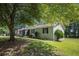 Exterior view of the home showing the side yard, screened porch, and surrounding mature trees at 2780 Highpoint Rd, Snellville, GA 30078