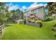 Spacious backyard features a manicured lawn, mature trees, and multilevel patio at 4715 Mcintosh Drive Dr, Cumming, GA 30040