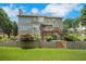 Large backyard with multilevel patio, mature trees, lush lawn, and fenced perimeter at 4715 Mcintosh Drive Dr, Cumming, GA 30040