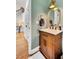 Stylish half bathroom with modern vanity, marble countertop, brass fixtures, and wood flooring at 4715 Mcintosh Drive Dr, Cumming, GA 30040