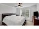 Bedroom with neutral carpet, ceiling fan, window and a dark wood dresser and bed frame at 4715 Mcintosh Drive Dr, Cumming, GA 30040