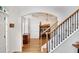 Entryway showcasing wood floors, a staircase with ornamental black iron, and a view of the dining room at 4715 Mcintosh Drive Dr, Cumming, GA 30040