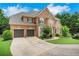 Beautiful brick home featuring an attached two-car garage, lush landscaping and a curved driveway at 4715 Mcintosh Drive Dr, Cumming, GA 30040