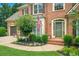 Inviting front entrance of brick home, featuring a two-car garage, landscaped garden, and green front door at 4715 Mcintosh Drive Dr, Cumming, GA 30040
