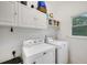 Clean laundry room featuring upper cabinets and side-by-side washer and dryer at 4715 Mcintosh Drive Dr, Cumming, GA 30040
