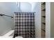 Bright bathroom featuring plaid shower curtain, modern vanity, and wall shelving at 1002 Creatwood Se Cir, Smyrna, GA 30080